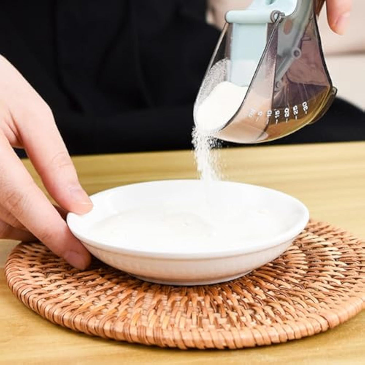 Scoop pouring food into a bowl